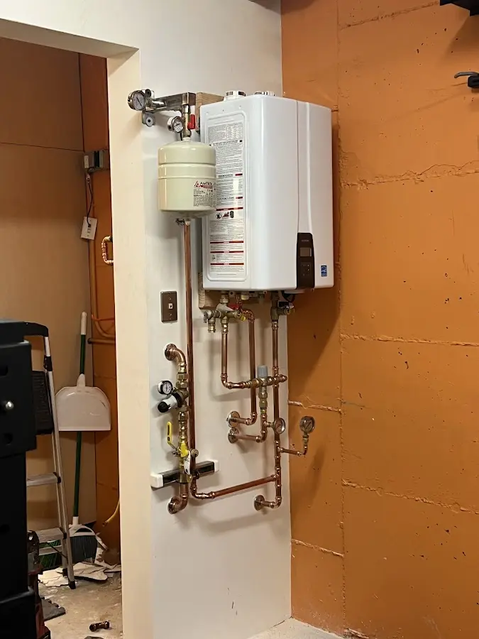 Plumbing technician inspecting water heater connections in Somerdale